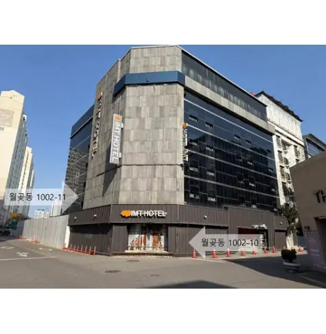 외벽을 함께 감싼 두 동 — 왼쪽 1002-11(유찰), 오른쪽 모퉁이 1002-10(낙찰). 출처: 온비드 첨부 감정평가서 사진(2026-10-19 보관)